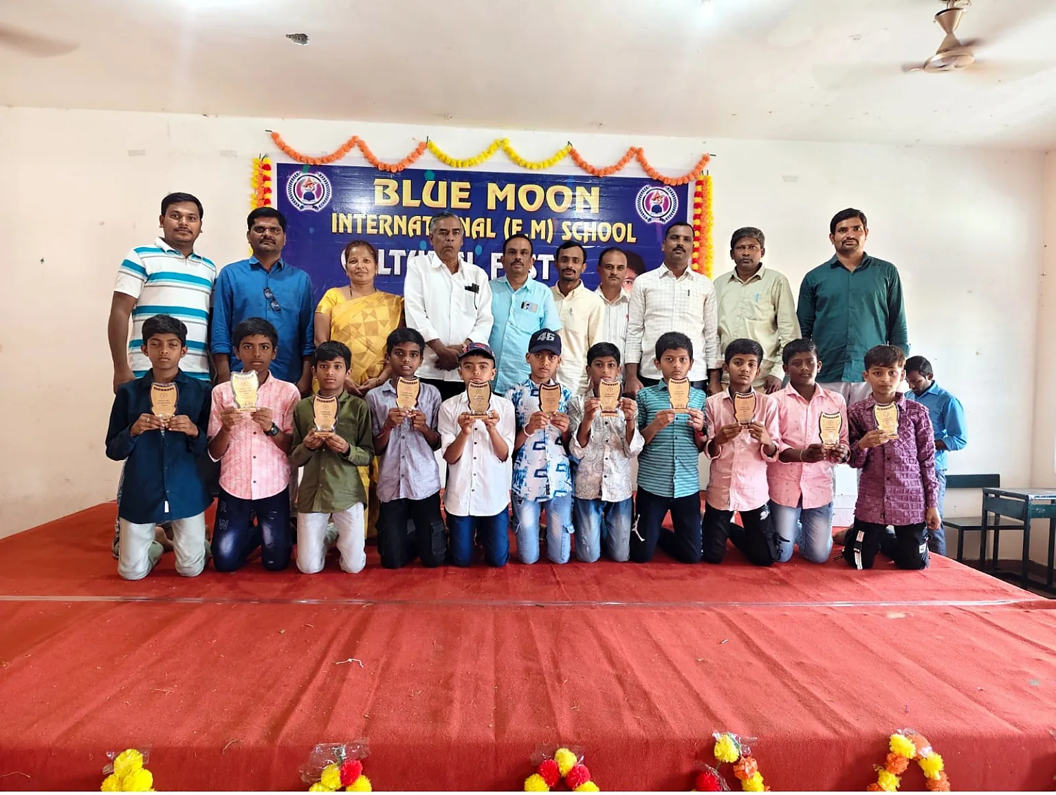 Blue Moon boys holding trophies at cultural fest