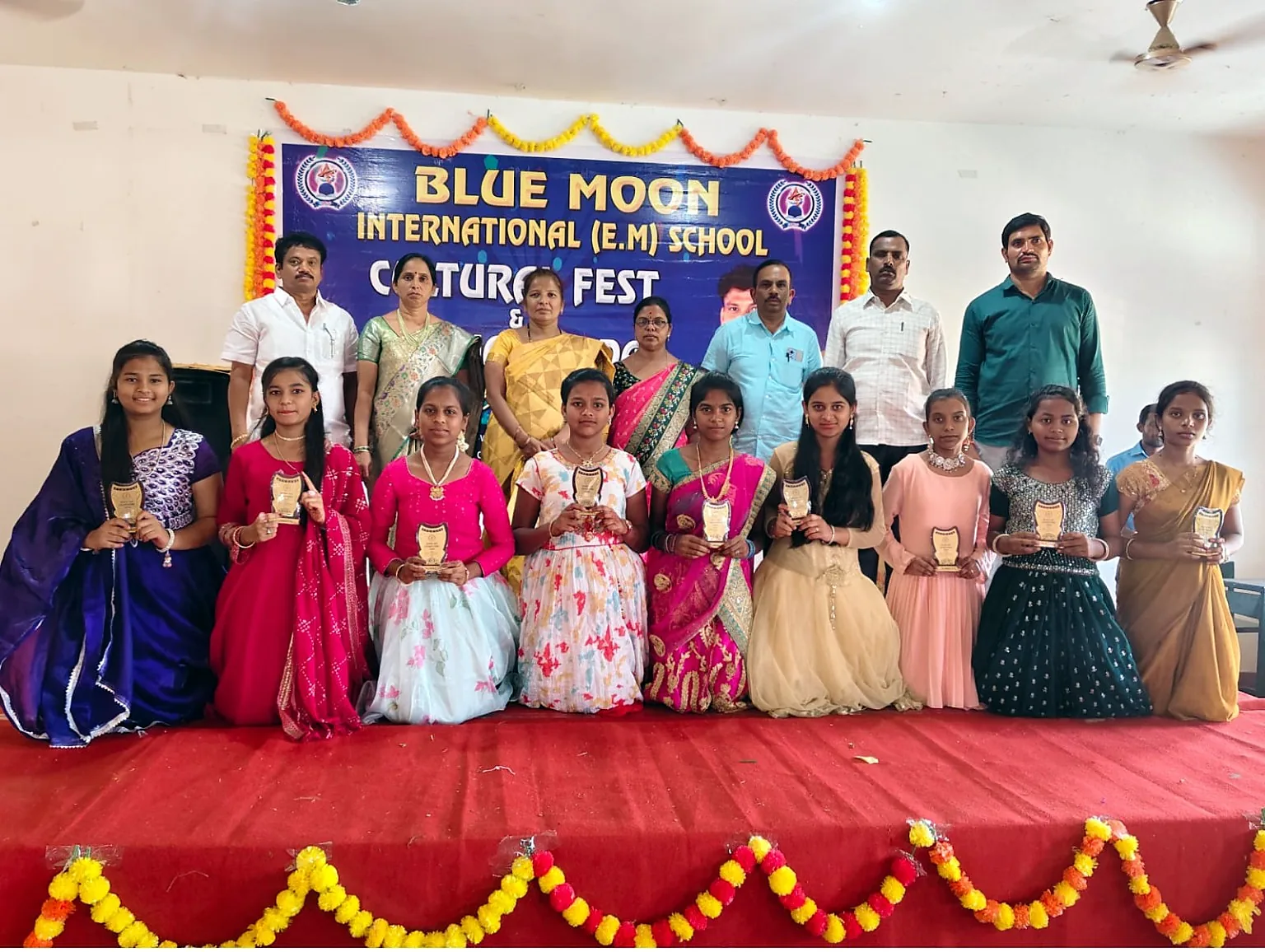 Blue Moon girls holding trophies at cultural fest