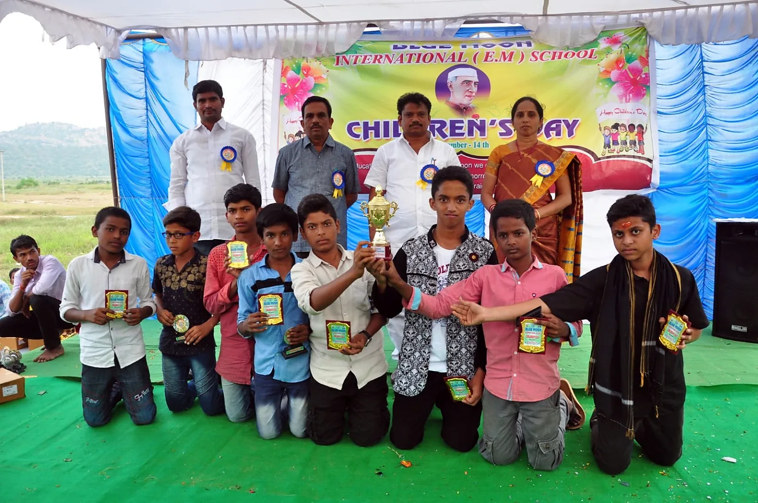 Blue Moon students on Children Day stage with sports trophies